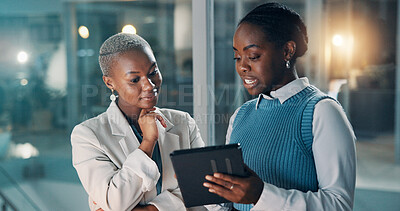 Buy stock photo Night, business people and discussion in office with tablet, financial review and deadline for audit. Late, black women and conversation with tech, problem solving and planning for accounting report.