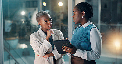 Buy stock photo Night, black people and talk in office with tablet, financial review or deadline for company audit. Late, women and discussion in workplace with tech, problem solving or business plan for accounting.