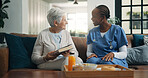 Smile, nurse and old woman with book in home for homecare, support and healthcare at breakfast. Caregiver, elderly person and literature in house, medical wellness and relax with novel in retirement