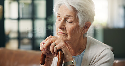 Buy stock photo Cane, sad and thinking with old woman on sofa in living room of home for grief, loss or pain. Reflection, senior and walking stick of person with depression in apartment for memories or nostalgia