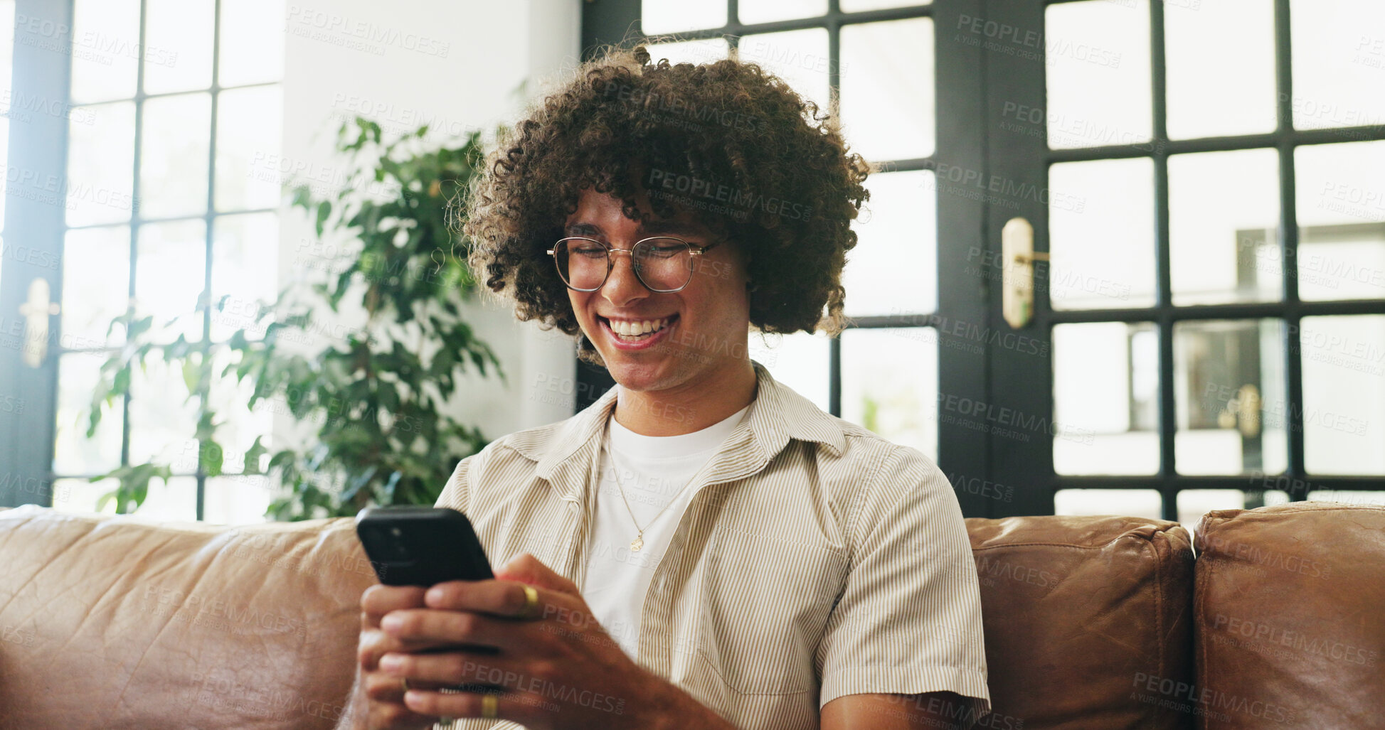 Buy stock photo Phone, happy and man on sofa in home with networking, communication or chatting on mobile app. Relax, smile and male person with cellphone for online texting, blog or contact in living room at house.