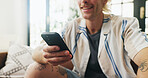 Phone, hands and man on sofa in home with networking, communication or chatting on mobile app. Relax, smile and male person with cellphone for online texting, blog or contact in living room at house.