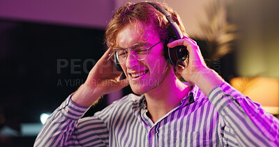 Buy stock photo Happy, man and music with headphones, smile and listening to audio track for broadcast at night. Radio, male person and streaming song with technology for media, subscription and neon light in home