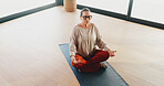Zen, yoga and woman with meditation in studio for holistic wellness, relax or inner peace. Above, mature female person or lotus pose on mat for mental health, mindfulness or chakra balance with space