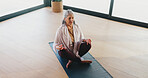 Yoga, senior woman and meditation in studio for stress relief, grounding practice or mindfulness. Above, old person or lotus pose on mat for mental health, inner peace or holistic wellness with space