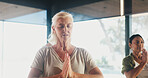 Mature woman, meditation and prayer hands at yoga studio with mudra for breathing exercise in gym. Person, holistic fitness and mindfulness at class, namaste pose and group with zen at wellness club