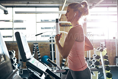 Buy stock photo Music, exercise and woman running on treadmill for fitness, wellness and listening to audio in gym. Cardio machine, earphones and person training in health club for workout, challenge and energy