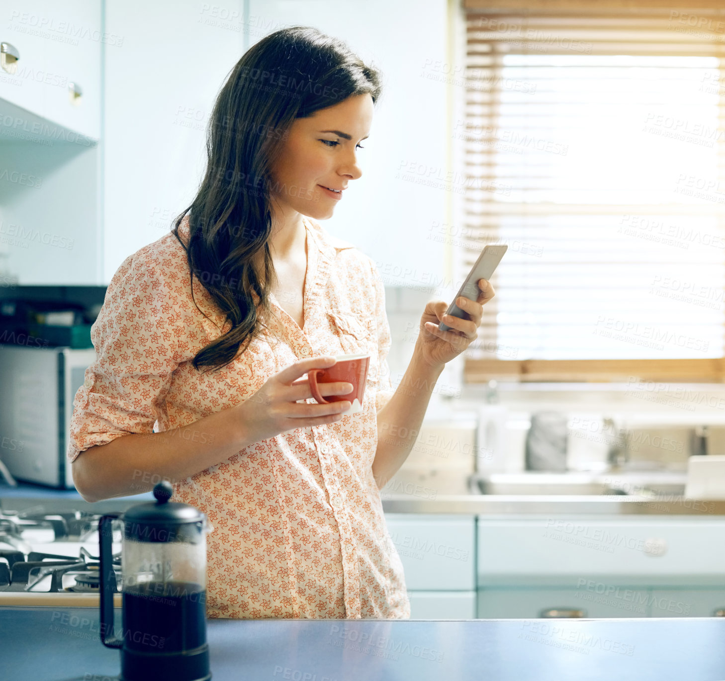 Buy stock photo Woman, phone and coffee with texting in home with smile, contact and online dating in kitchen. Person, happy and smartphone with drink, beverage and mobile app with chat on social media at house