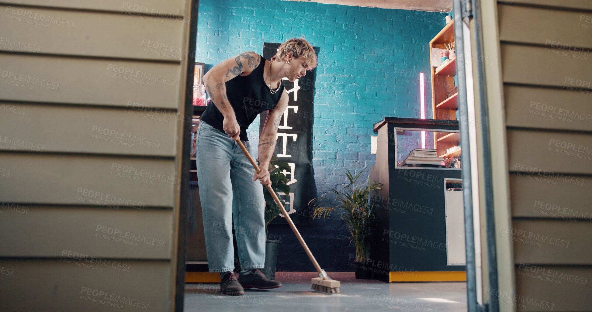 Buy stock photo Cleaning, broom and small business with man in tattoo parlor for preparation or start of work. Hygiene, maintenance and sweeping with person in startup studio for chores, responsibility or tasks