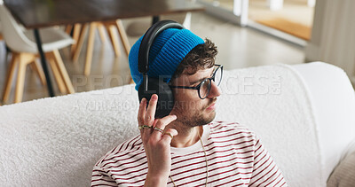 Buy stock photo Headphones, relax and man on couch in home with music, playlist or radio on weekend. Thinking, audio technology and male person streaming album, podcast or song online in living room at apartment