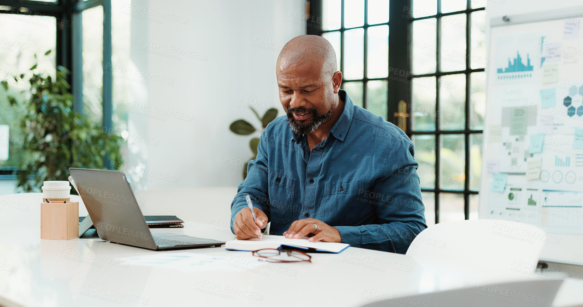 Buy stock photo Laptop, writing and business black man with notebook for financial review, statistics or budget report. Startup office, planning and person with graphs, documents and research for finance analysis