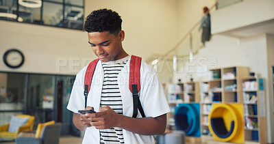 Buy stock photo Education, phone and typing with boy student on high school campus for communication or study. App, learning and text message with teen learner in corridor for classroom schedule or timetable