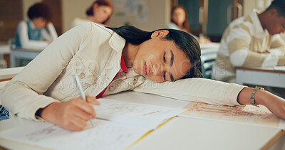 Buy stock photo Tired, education and student in classroom with test, exam or assignment with fatigue or burnout. Writing, learning and girl teenager in lesson with exhaustion for studying with quiz at school.