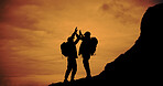 Sunset, silhouette and friends with celebration for hiking on mountain for vacation, adventure or holiday. Travel, shadow and men with high five for backpacking goal on weekend trip for trekking.