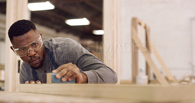 Buy stock photo Carpenter, man and sandpaper in workshop with timber, woodwork or project for furniture manufacturing. Woodworker, black person and sanding tools in factory with glasses, carpentry and craftsmanship.