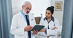 Doctors, tablet and team with report at hospital with discussion, planning or insight for medical review. Mature mentor, man and woman with tech, app and feedback for healthcare services at clinic