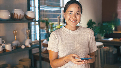 Buy stock photo Phone, portrait and typing with woman in pottery boutique for management of small business. App, schedule and startup with happy store owner in ceramics gallery for decoration or retail sale