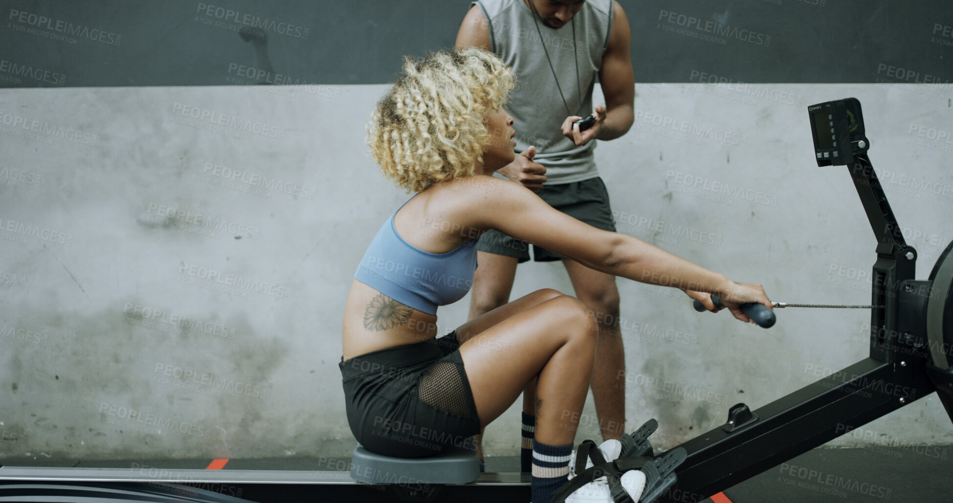 Buy stock photo Woman, exercise and personal trainer in gym with rowing machine, endurance and strength training. Space, people and coach in health club with ergometer, stopwatch and HIIT workout for fitness goals.