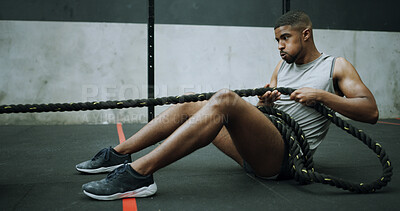 Buy stock photo Man, ropes and exercise on gym floor with pull, intense workout and resilience with challenge. Person, fitness and power with breathing, resistance and training for muscle benefits with gear
