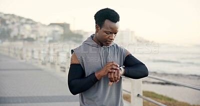 Buy stock photo Beach, training and black man with smart watch, fitness or digital app to track progress. Check time, person or athlete with exercise, challenge or monitor heart rate for cardio workout and ocean