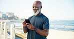Old man, scroll and fitness by beach with phone, social media and notification for wellness app. Senior black person, typing and tech on promenade outdoor with text message, exercise or workout rest.