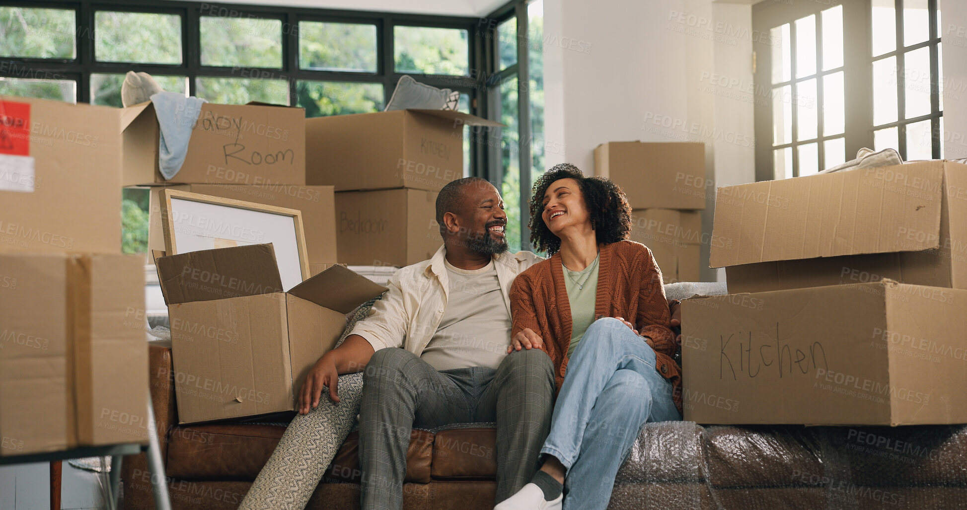 Buy stock photo Moving, couple and relax in new home, laughing and relocation for property investment. African man, woman and dream house with mature people, real estate and funny homeowners on sofa in living room