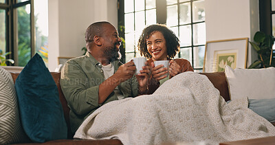 Buy stock photo Relax, coffee cup or couple with smile on sofa, funny conversation or partner joke for weekend bonding. Love, laugh and mature African people with tea to chill, comfortable and chat together in home