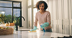 Woman, cleaning or detergent with surface in kitchen for hygiene, housekeeping or sanitization. Female person, spray bottle and gloves with cloth on counter for bacteria, germ or dirt removal in home