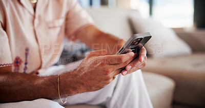 Buy stock photo Phone, hands and man on sofa in home with networking, communication or social media on mobile app. Relax, technology and male person texting online with cellphone in living room at apartment.