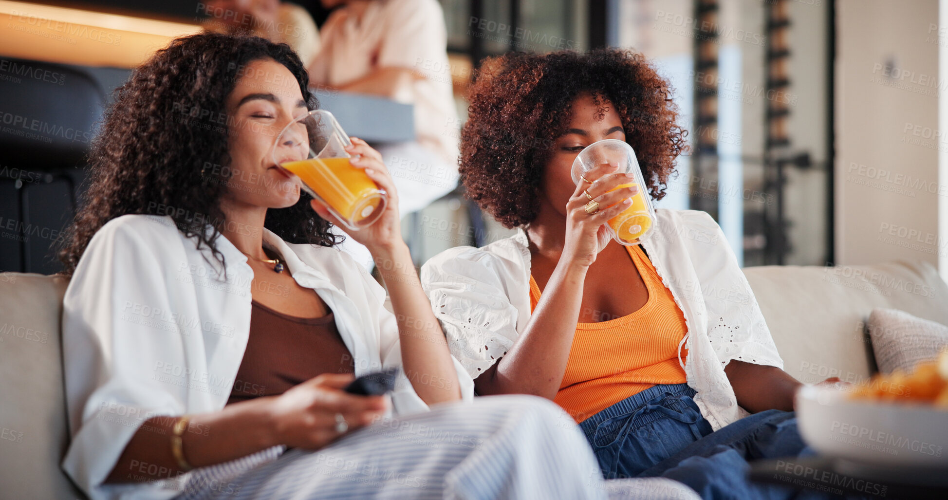 Buy stock photo Women, friends and watching tv with drinks on sofa with juice, bonding and relax in home for movies. People, glasses and television on couch for streaming service, subscription or film at apartment