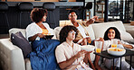 Couple of friends and excited, relax and watching tv on sofa for sport game, point or snack in living room. People, happy and drinks on couch for talk, subscription and television in lounge at home