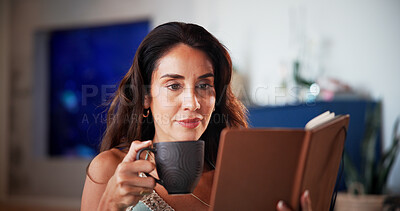Buy stock photo Coffee, reading and woman with book in home for hobby, relax and literature for knowledge. Happy, mature and person with drink and novel, story or fantasy for peace, calm and learning in living room