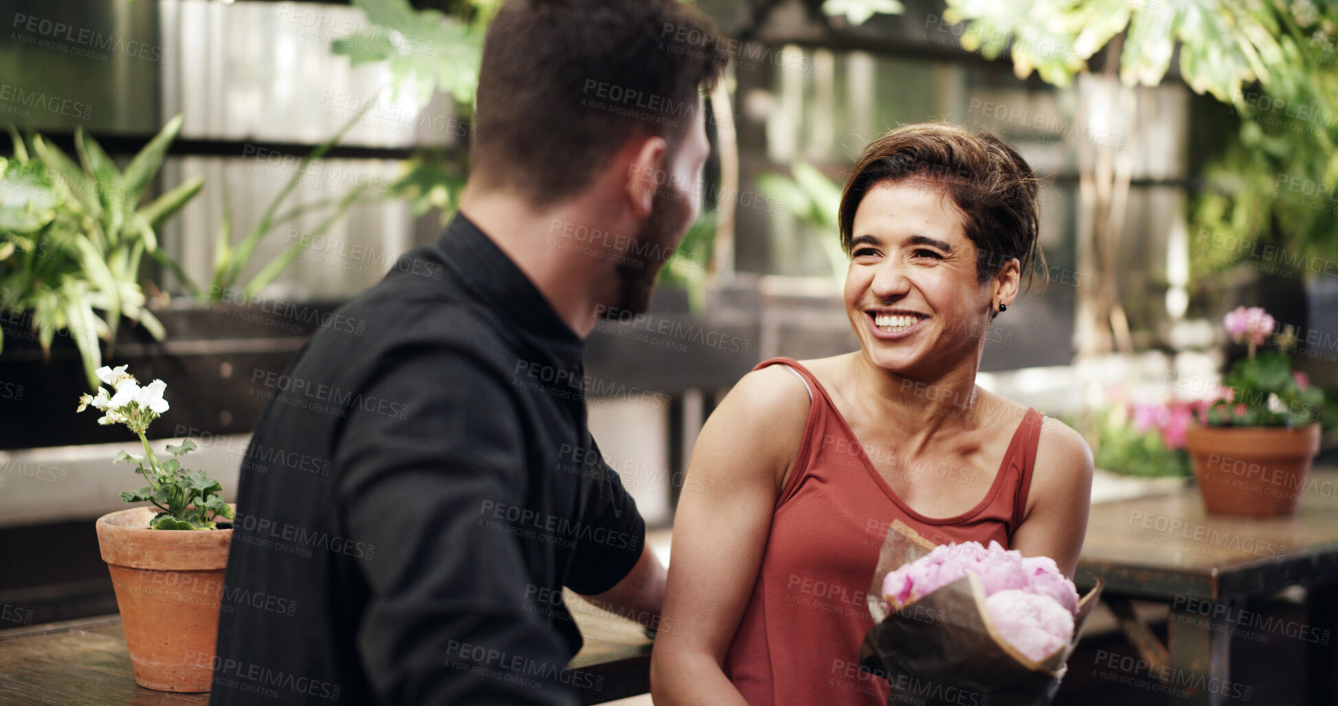 Buy stock photo Happy, couple and woman with flowers, cafe and present for anniversary, together and romance on date. Love, man and floral gift for partner with smile, celebration and bouquet for valentines day