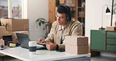 Buy stock photo Boxes, clipboard and headphones with man in logistics office for delivery of online order. Laptop, music and writing with distribution or supply chain employee at work for ecommerce or shipping
