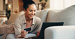Laptop, payment and happy woman in living room with credit card, online shopping discount or cashback. Person, smile and digital banking in home with computer, fintech or ecommerce sale for purchase.