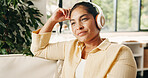 Woman, relax and thinking on couch with headphones, online podcast and listening to music for nostalgia. Mature person, reflection or remember memory in home with audio tech, streaming radio or song.