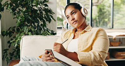 Buy stock photo Woman, thinking and headphones on sofa with notebook, podcast or inspiration for self improvement. Mature person, audio tech and vision in home with journal, online radio or tips for personal growth.