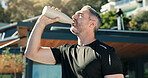 Outdoor, athlete and man with water, fitness and body recovery after exercise routine, rest and home. Drinking, liquid and mature person with bottle for hydration, thirsty and wellness with drink
