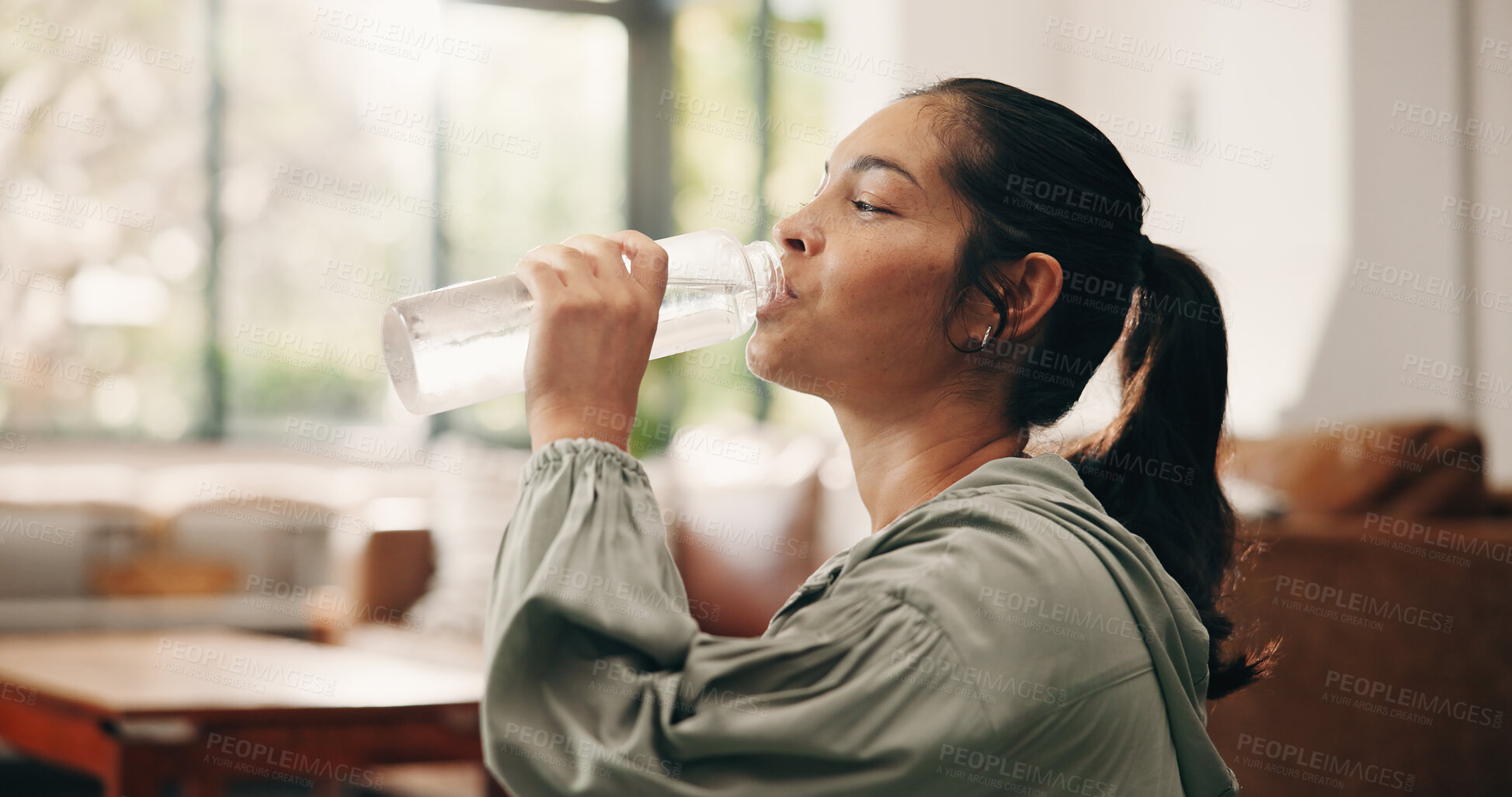 Buy stock photo Woman, relax or drinking water in living room with bottle, wellness or natural detox for gut health. Thirsty, mature person and liquid beverage in home with hydration, nutrients or digestion benefits