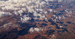 Aerial view, clouds and landscape with mountains, nature and shadow on ground, outdoor and earth in summer. Above, horizon and weather with terrain, hills and environment in rural countryside