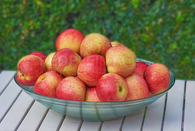 Buy stock photo Outdoor, pile and apple in bowl on table, fresh organic produce and healthy snack for balanced diet. Nutrition, natural food and fruit with fiber for wellness, weight loss and  gut health benefits