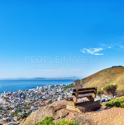 Buy stock photo Bench, landscape and mountain with city in nature for travel, urban skyline and holiday location. Space, ocean and blue sky with infrastructure, architecture and residential area on vacation outdoor
