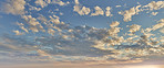 Sunrise, orange and blue sky with clouds for weather, atmosphere and empty space. Natural, background and air with sunshine in morning for aesthetic, wallpaper and scenic view for nature or climate