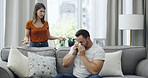 Couple, argument and fight with disagreement on sofa for emotional breakup or divorce in home. Sad, man and woman with tissue for toxic relationship, conflict or living room dispute together in house