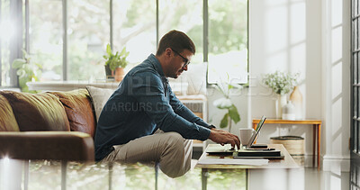 Buy stock photo Typing, remote work and man with laptop in house for account manager, client portfolio and research. Admin, feedback and networking with person in living room for planning or thinking in home office