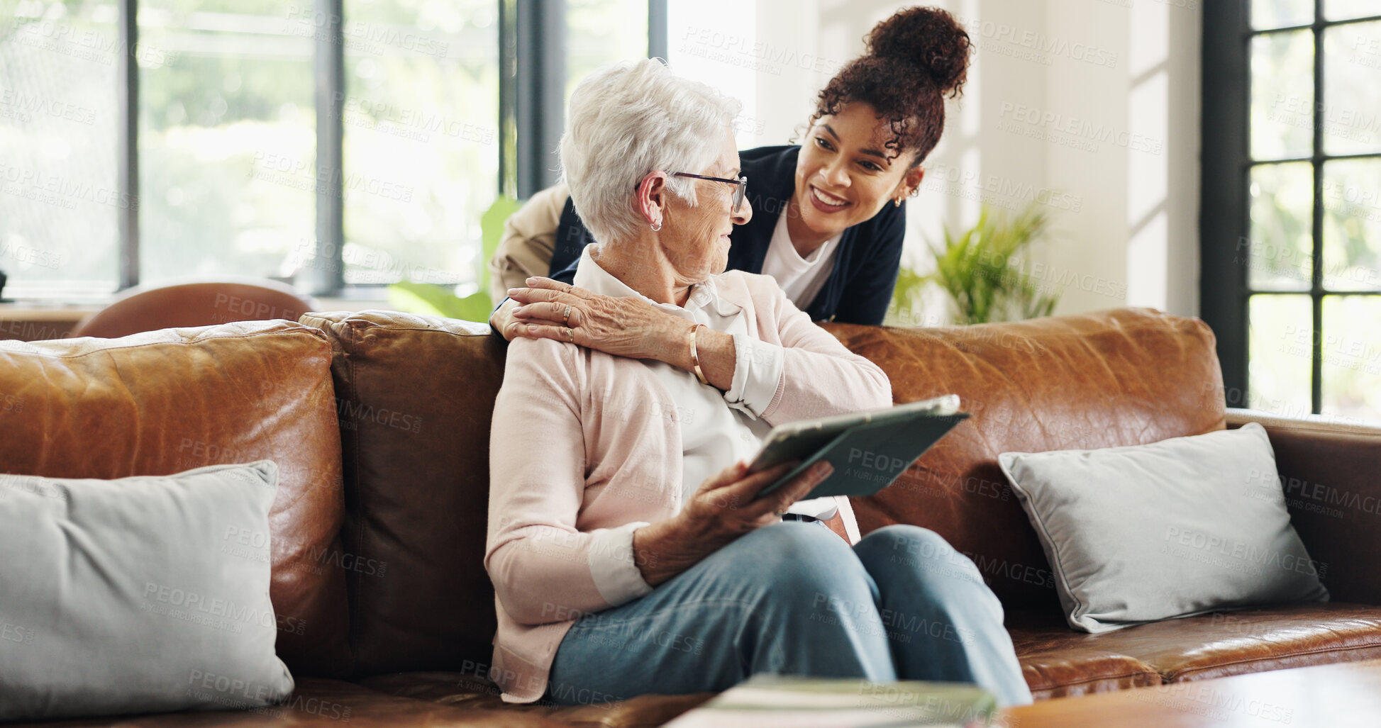 Buy stock photo Happy, caregiver and old woman with tablet, lounge and bonding with patient on break or hug in home. Online, entertainment and senior person with tech for movies, retirement and embrace with nurse