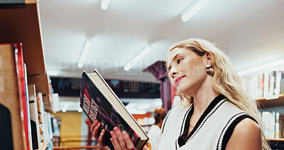 Buy stock photo Student, girl and reading a book at bookshelf for college research, microbiology and knowledge. University, person and check course resources in library for thesis citation, science info and learning