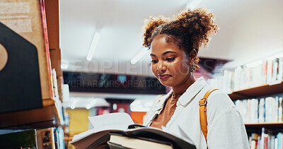 Buy stock photo Student, girl and reading book at shelf on campus for research, exam info or knowledge. College, african person or check course resources in library for thesis citation, literary interest or learning