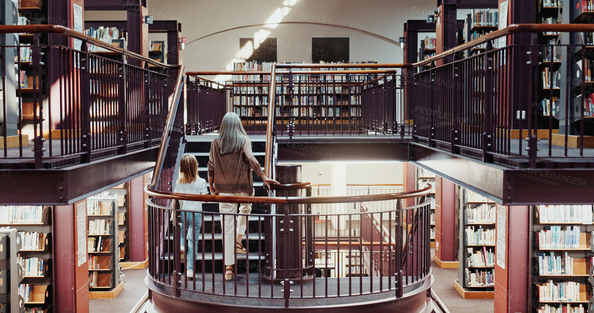Buy stock photo Grandma, walking and holding hands with child in library for education, learning or literature. Grandparent, kid or granddaughter on staircase in bookstore or shop for knowledge, story or novel