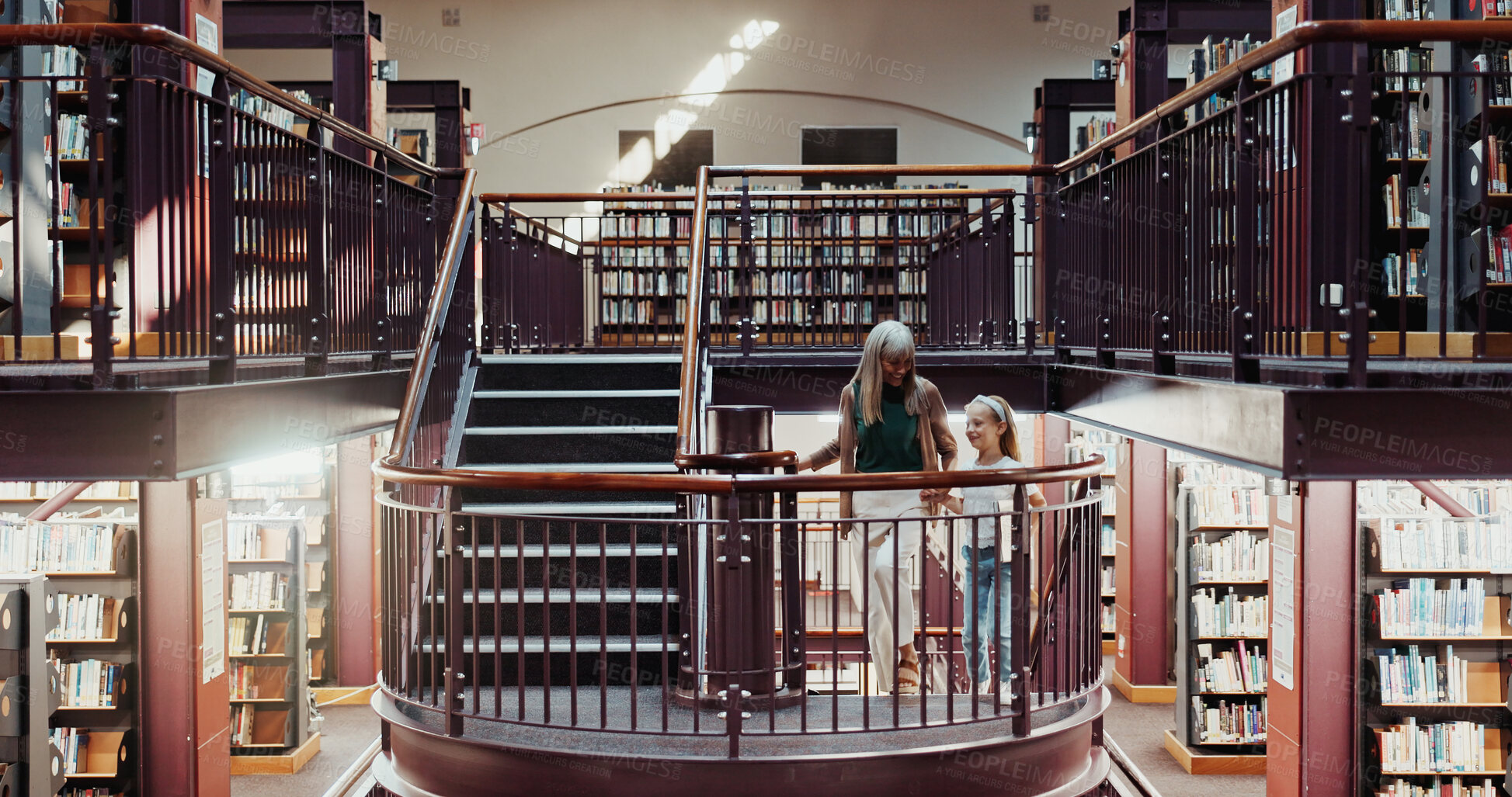 Buy stock photo Happy, grandma and holding hands with child in library for education, learning or literature. Grandparent, kid or helping granddaughter on staircase in bookstore or shop for knowledge, story or novel
